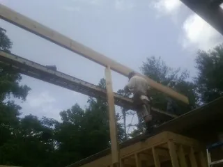 Carpenter setting a ridge beam over a new addition frame — Ice Dam Removal by Roofing Brothers in Troutdale