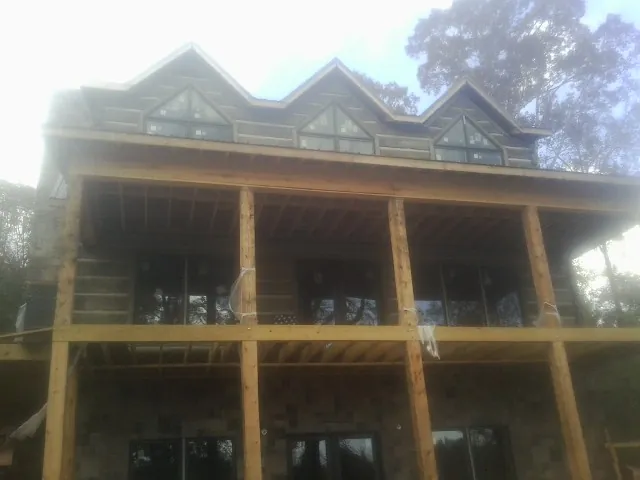 Dormers and porch framing on a large log home under construction — Roof Coating work by our crew in Troutdale