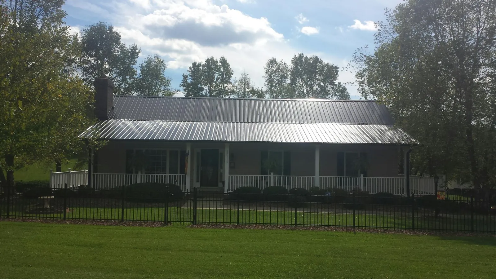Gray metal roof on a brick ranch with a full width front porch — Gutter Guard Installation work by our crew in Troutdale